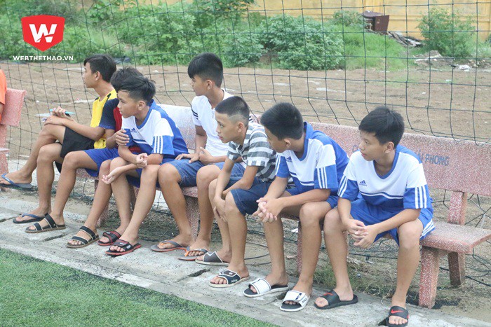 Bên ngoài sân, các cầu thủ THCS Ngô Thị Nhậm chăm chú theo dõi các bạn tập luyện