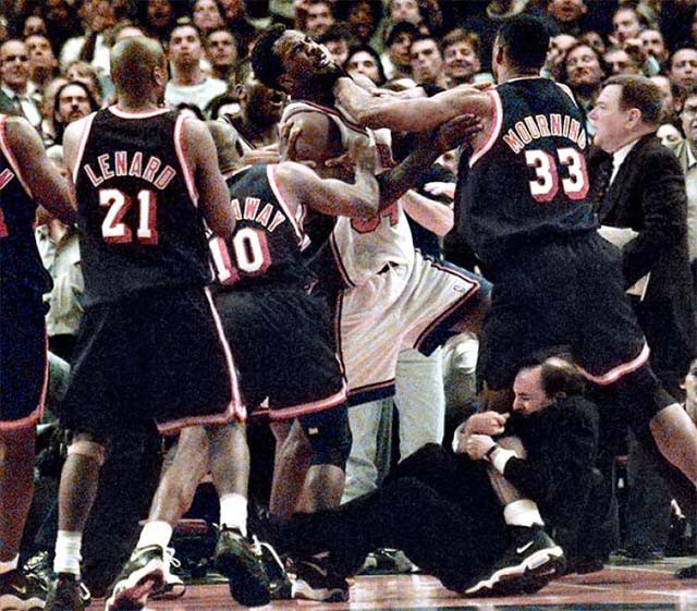 HLV Jeff Van Gundy của Knicks túm chặt lấy chân của cầu thủ Heat 