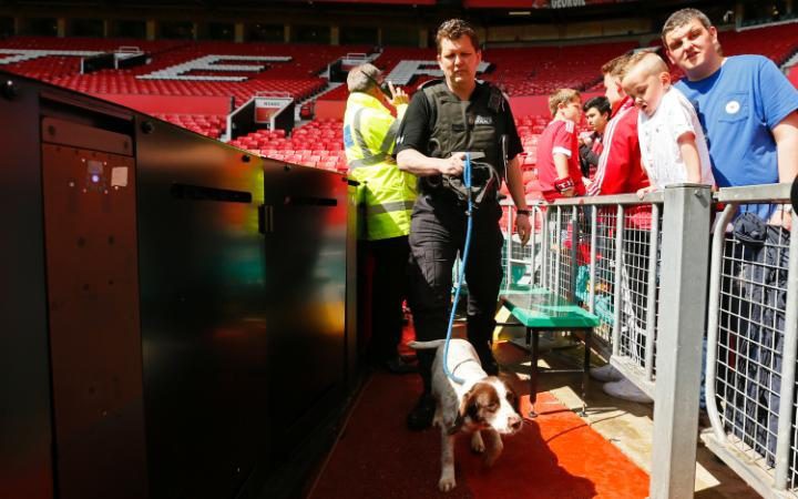 Nhân viên an ninh dắt chó nghiệp vụ rà soát sân Old Trafford.