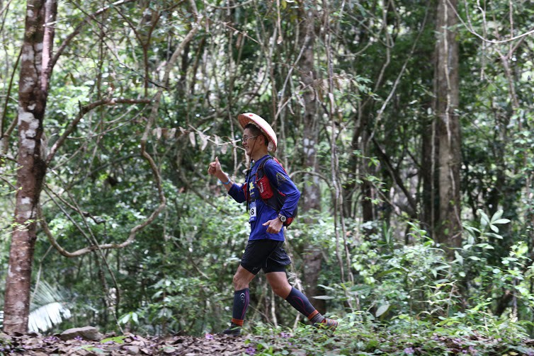 Một VĐV Nhật đội nón chạy đường rừng