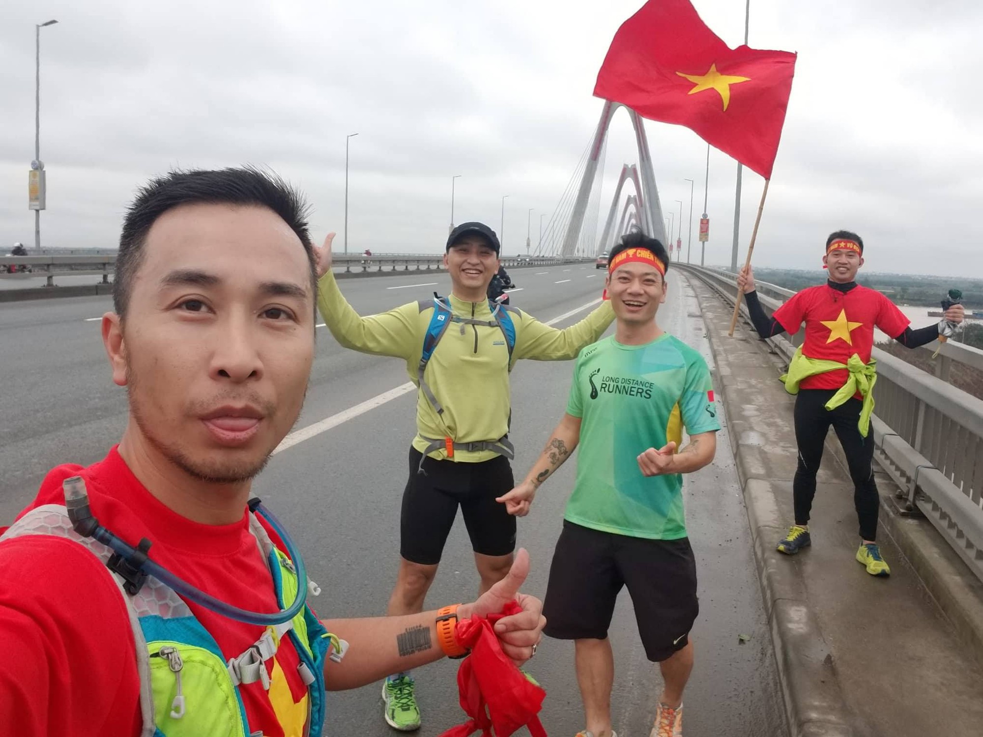 Các ''running man'': Tô Hiếu Trung, Cường Trần, Nguyễn Thế Anh, Vũ Vương tại đầu cầu Nhật Tân chạy bộ với áo và cờ Tổ quốc