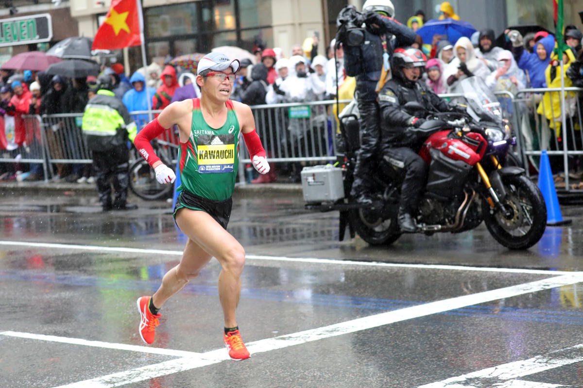 Hình ảnh tân vô địch Yuki Kawauchi cán đích Boston Marathon 2018, phía sau là quốc kỳ Việt Nam được treo cùng với cờ của hơn 90 quốc gia có VĐV tham dự