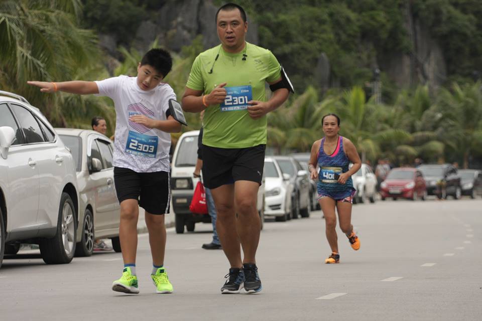 VĐV Phạm Vũ Hoàng Anh (11 tuổi) chạy half marathon cùng với bố. Hoàng Anh là VĐV nhỏ tuổi nhất giải hoàn thành 21km. Ảnh: Trịnh Nam Hải