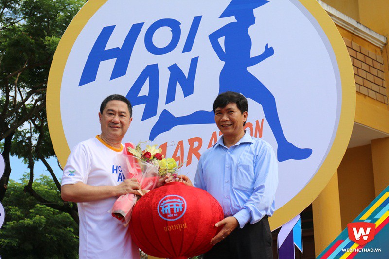 Ông Nguyễn Văn Sơn (phải), PCT UBND TP Hội An trao quà lưu niệm chiếc đèn lồng với biểu tượng cầu Nhật Bản cho đại diện BTC giải