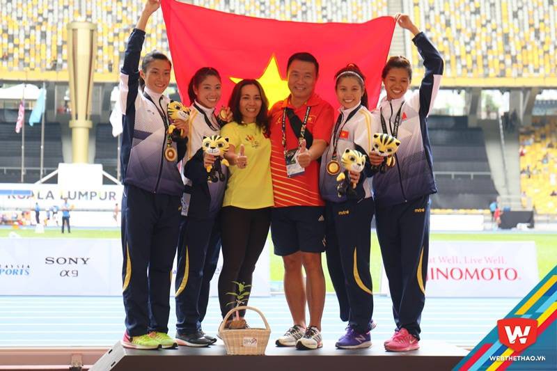 HLV Nguyễn Thị Thanh Hương, HLV Vũ Ngọc Lợi cùng các học trò 4x100m trên bục chiến thắng. Ảnh: Nguyễn Đạt