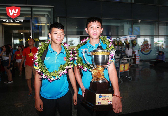 Chiếc cúp vô địch danh giá được đội trưởng Tiến Long (phải) cùng đồng đội Văn Cường rước ra một cách vô cùng trang trọng...