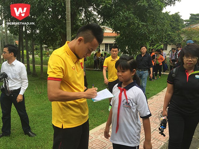 Tiền vệ Huy Toàn vui vẻ ký tặng các em nhỏ có hoàn cảnh khó khăn.