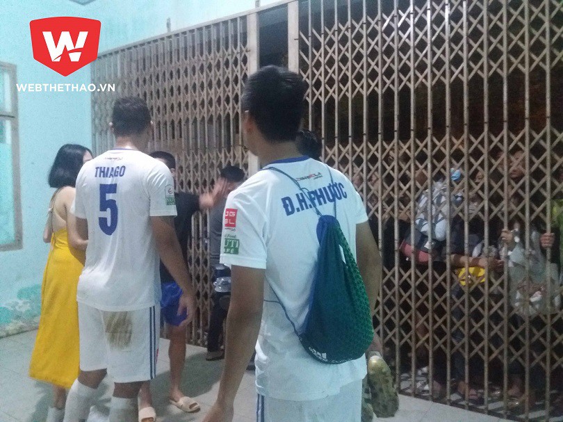 Để về đến địa điểm nghỉ ngơi, mỗi khi đi qua cánh cửa này, các cầu thủ Quảng Nam chỉ được bảo vệ sân hé mở một khoảng nhỏ. Ảnh: Trần Khánh