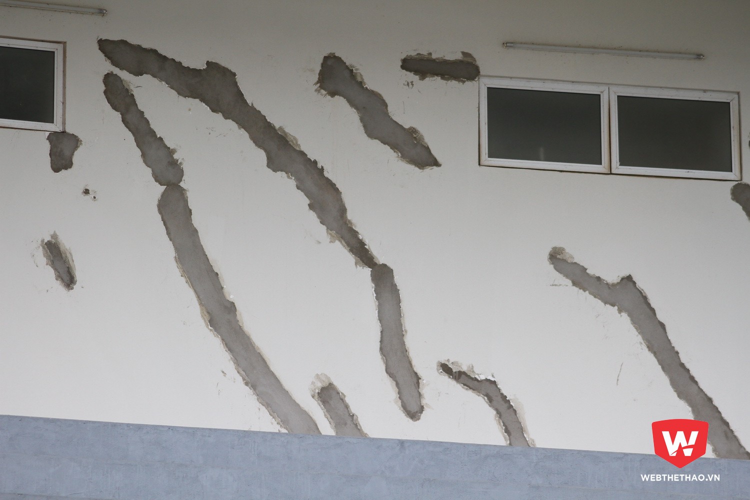 Các vết nứt được trám bằng vữa trộn hợp chất sica latex trước khi sơn lại ở khu vực bên trong bờ tường khán đài A. Ảnh: Trần Khánh
