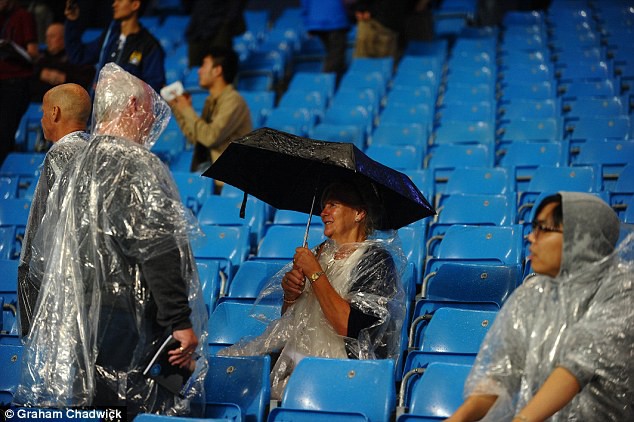 Nữ CĐV lớn tuổi của Man City mang dù và mặc áo mưa đến cổ vũ đội nhà