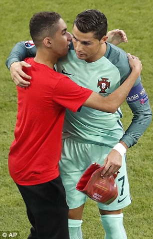 Cậu bé áo đỏ hạnh phúc ôm Ronaldo.