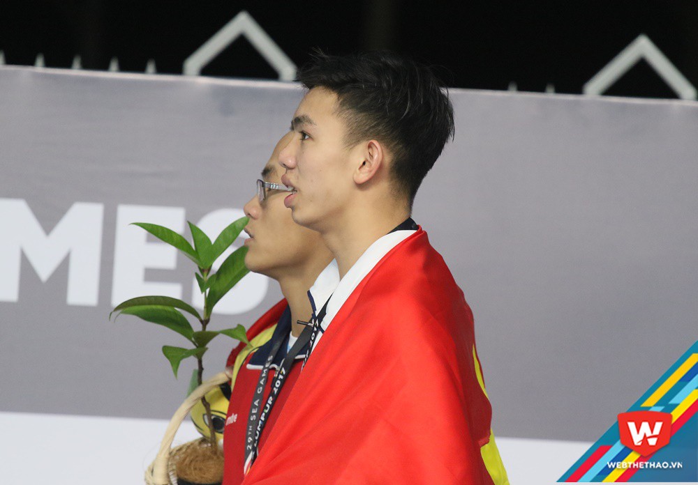 Khoảnh khắc Huy Hoàng và Quang Nhật cùng đứng ngang để khoác cờ tổ quốc hát quốc ca. Ảnh: Văn Nhân