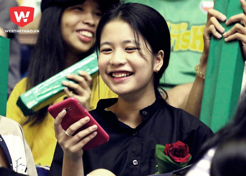 Một fan nữ cười hạnh phúc với hoa hồng và thiệp trên tay. Ảnh: Văn Nhân