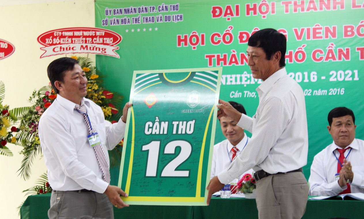 HLV Vũ Quang Bảo tặng hình ảnh cầu thủ 12 cho CĐV Cần Thơ có đầy đủ chữ ký của đội XSKT.Cần Thơ. Ảnh: VĂN NHÂN