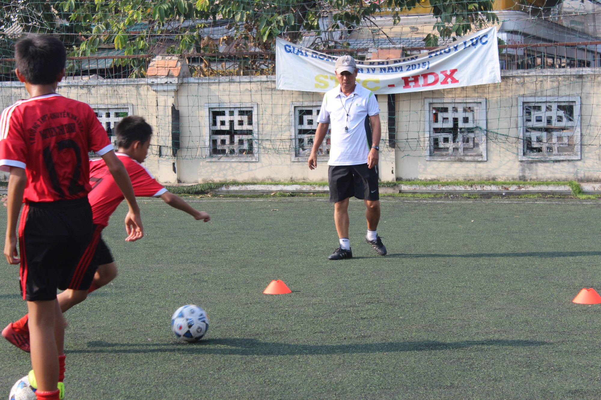 Chuyên gia Đoàn Minh Xương đang dạy cho các em chơi bóng tại trường Nguyễn Thị Định (TP.HCM). Ảnh: VĂN NHÂN