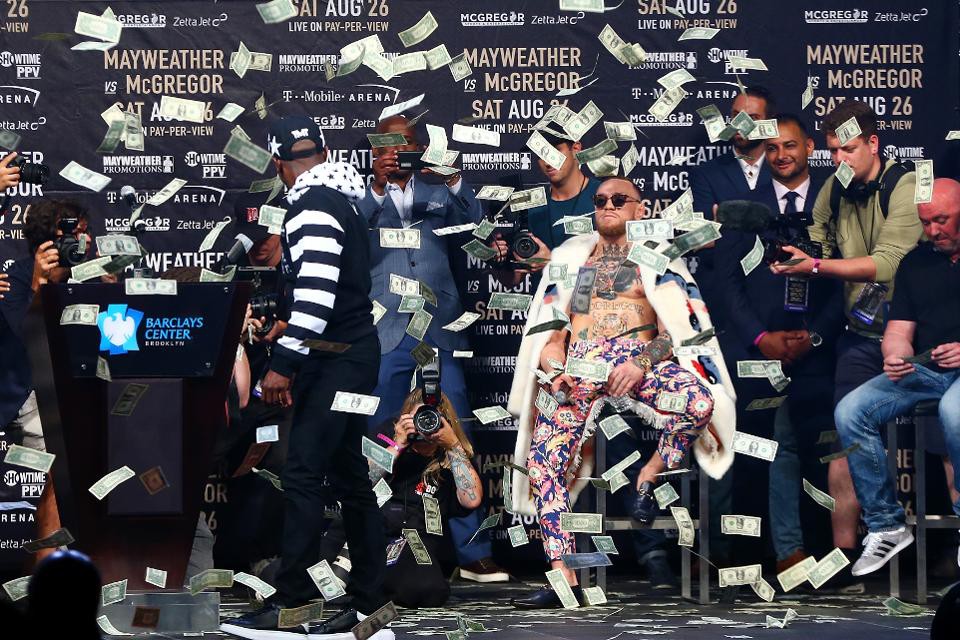 Floyd Mayweather tung tiền về phái McGregor trong buổi họp báo tại New York. Ảnh: Forbes