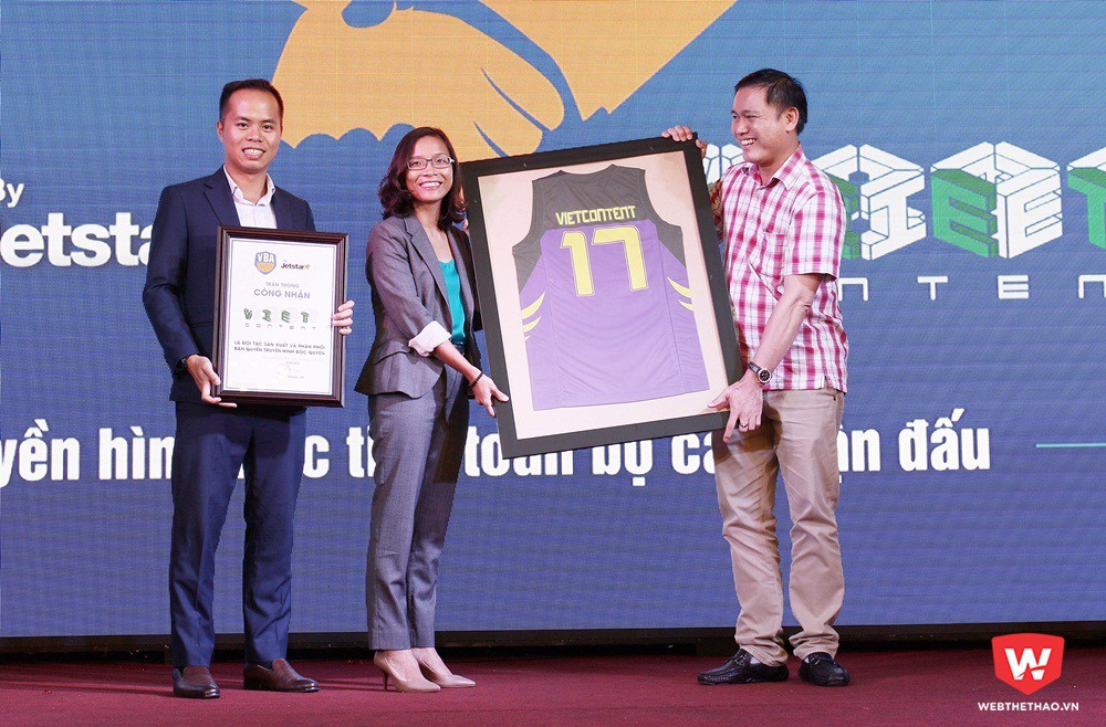 Bà Trần Thùy Chi - Chủ tịch HĐQT Vietcontent (giữa) nhận chiếc áo đấu kỷ niệm từ tay Chủ sở hữu đội HCMC Wings Trần Anh Tú. Ảnh: Văn Nhân.