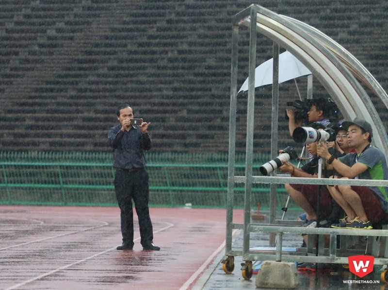 Thích thú với cảnh tượng phóng viên tác nghiệp dưới trời mưa, ông Thái Bá Y cũng ghi lại để làm kỷ niệm. Ảnh: Quang Thịnh.