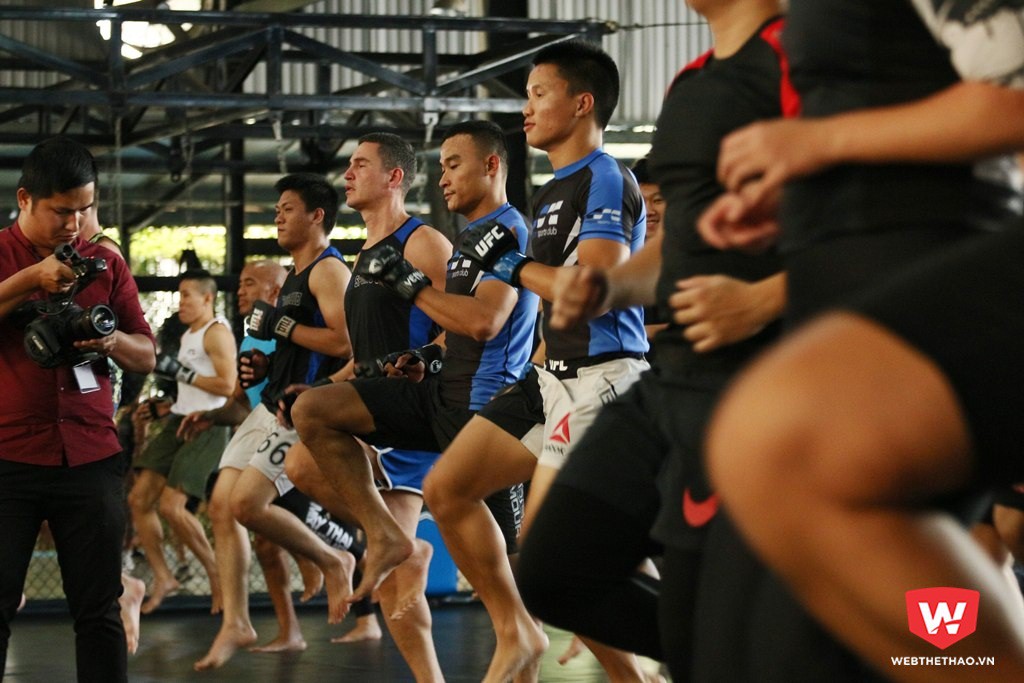 Ben Nguyễn (giữa) cùng các học viên và NHM MMA khởi động trên sàn thi đấu của Saigon Sport Club. Ảnh: Quang Thịnh.