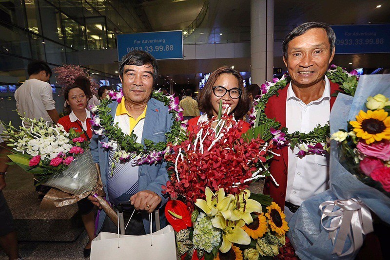 PCT Nguyễn Xuân Gụ (trái) và HLV Mai Đức Chung rạng rỡ ngày trở về sau chiếc HCV ở SEA Games cùng bóng đá nữ Việt Nam.