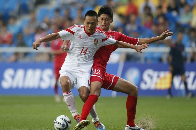 North Korea's Ri Yong Jik challenges China's Chang Feiya during their men's soccer qualifier match for the 17th Asian Games at Incheon Football Stadium in Incheon