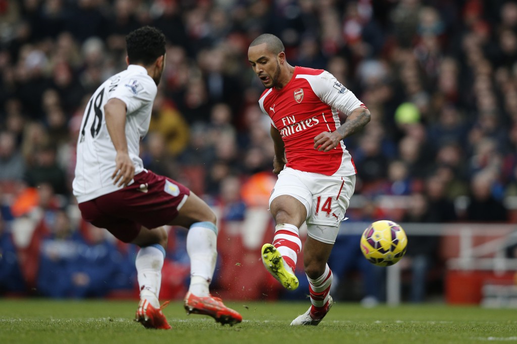 Arsenal's English midfielder Theo Walcott (R) scores their third goal during the English Premier League football match between Arsenal and Aston Villa at the Emirates Stadium in London on February 1, 2015. AFP PHOTO / ADRIAN DENNIS                                                                                                               RESTRICTED TO EDITORIAL USE. No use with unauthorized audio, video, data, fixture lists, club/league logos or "live" services. Online in-match use limited to 45 images, no video emulation. No use in betting, games or single club/league/player publications.