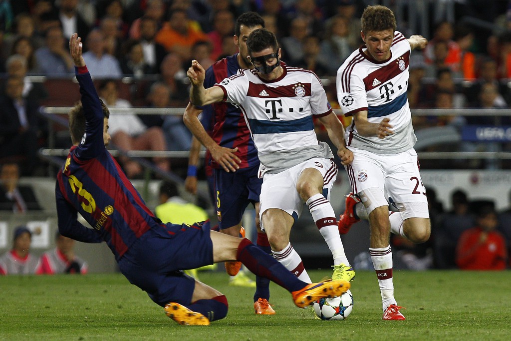 Bayern Munich's Polish forward Robert Lewandowski (C) is tackled by Barcelona's defender Gerard Pique (L) next to Bayern Munich's forward Thomas Mueller during the UEFA Champions League football match FC Barcelona vs FC Bayern Muenchen at the Camp Nou stadium in Barcelona on May 6, 2015.     AFP PHOTO/ QUIQUE GARCIA