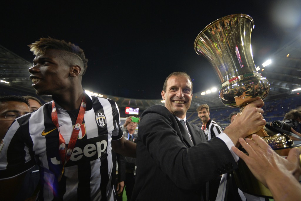 Juventus' coach Massimiliano Allegri (R) and Juventus' midfielder from France Paul Pogba celebrate with the trophy after winning 2-1 the Italian Tim Cup final match (Coppa Italia) between Juventus and Lazio on May 20, 2015 at the Stadio Olimpico in Rome.       AFP PHOTO / ANDREAS SOLARO