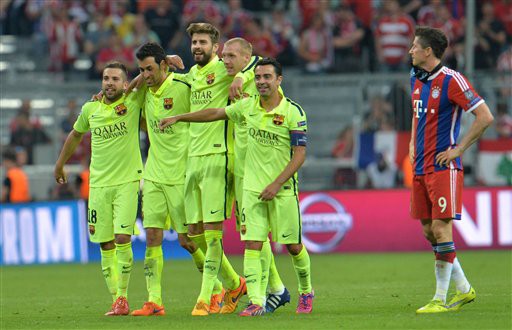 Barcelona players celebrate their victory next to Bayern's Robert Lewandowski, right, at the end of the soccer Champions League second leg semifinal match between Bayern Munich and FC Barcelona at Allianz Arena in Munich, southern Germany, Tuesday, May 12, 2015. (AP Photo/Kerstin Joensson)