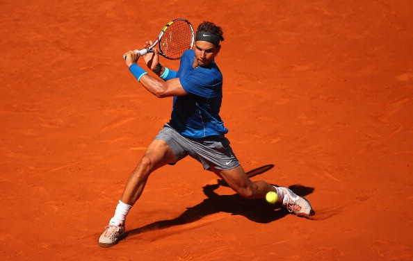 MADRID, SPAIN - MAY 09:  Rafael Nadal of Spain slides to reach a backhand against Tomas Berdych of the Czech Republic in their quarter final match during day seven of the Mutua Madrid Open tennis tournament at the Caja Magica on May 9, 2014 in Madrid, Spain.  (Photo by Clive Brunskill/Getty Images)