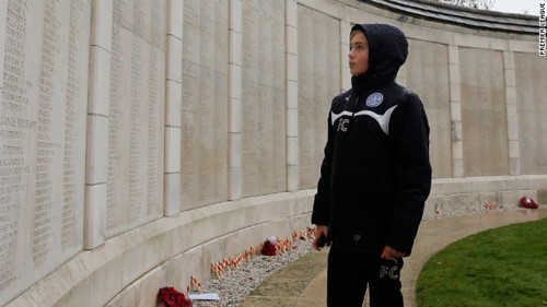 Một cầu thủ nhí trước bức tường ghi tên những người lính đã ngã xuống trong Thế chiến 1