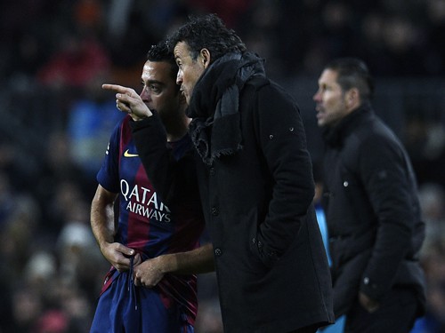 Barcelona's coach Luis Enrique talks with Barcelona's midfielder Xavi Hernandez during the Spanish Copa del Rey (King's Cup) quarter final first leg football match FC Barcelona vs Atletico de Madrid at the Camp Nou stadium in Barcelona on January 8, 2015. AFP PHOTO/ LLUIS GENE