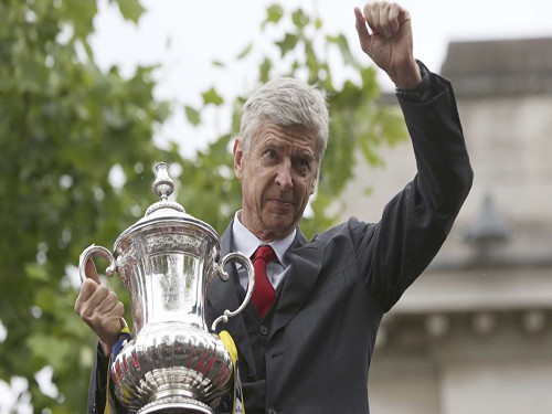 The Arsenal manager Arsene Wenger holds the FA Cup during Sunday's victory parade in north London.