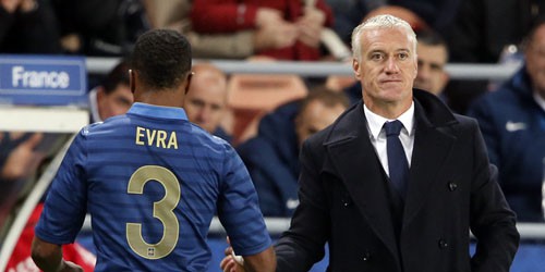 French player Patrice Evra  passes by head coach Didier Deschamps as he leaves the field during a friendly soccer match against Australia at the Parc Des Princes stadium in Paris