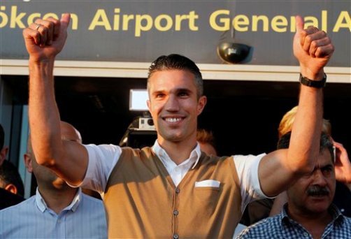 Robin Van Persie, of the Netherlands, gestures towards fans of Fenerbahce that gathered to welcome him at the airport in Istanbul, Sunday, July 12, 2015. The Dutch international arrived to sign a contract with the Turkish club. (AP Photo/Emrah Gurel)